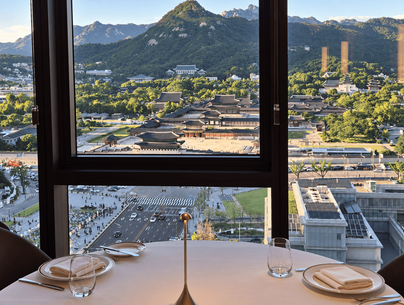 A restaurant table set for dinner before a window that looks out over Gyeongbokgung.