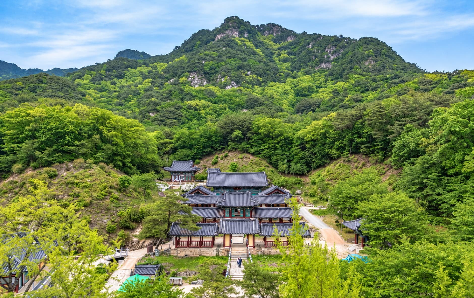 Temple halls in a green valley below a rocky mountain at Cheongpyeongsa Temple, Chuncheon.